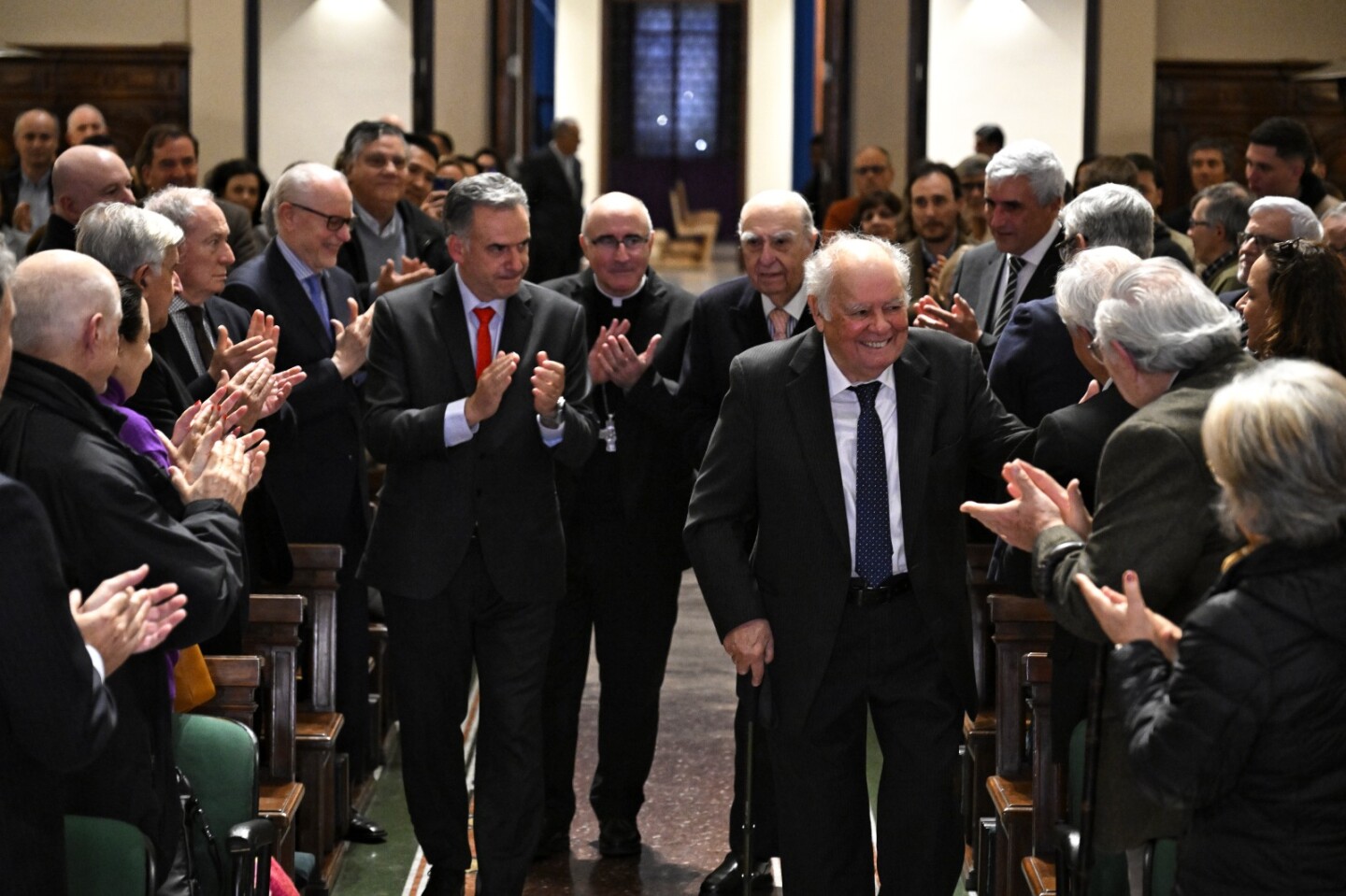 Enrique Iglesias ingresando al Aula Magna de UCU junto al presidente Yamandu Orsi, el exmandatario Julio María Sanguinetti y el cardenal Daniel Sturla.