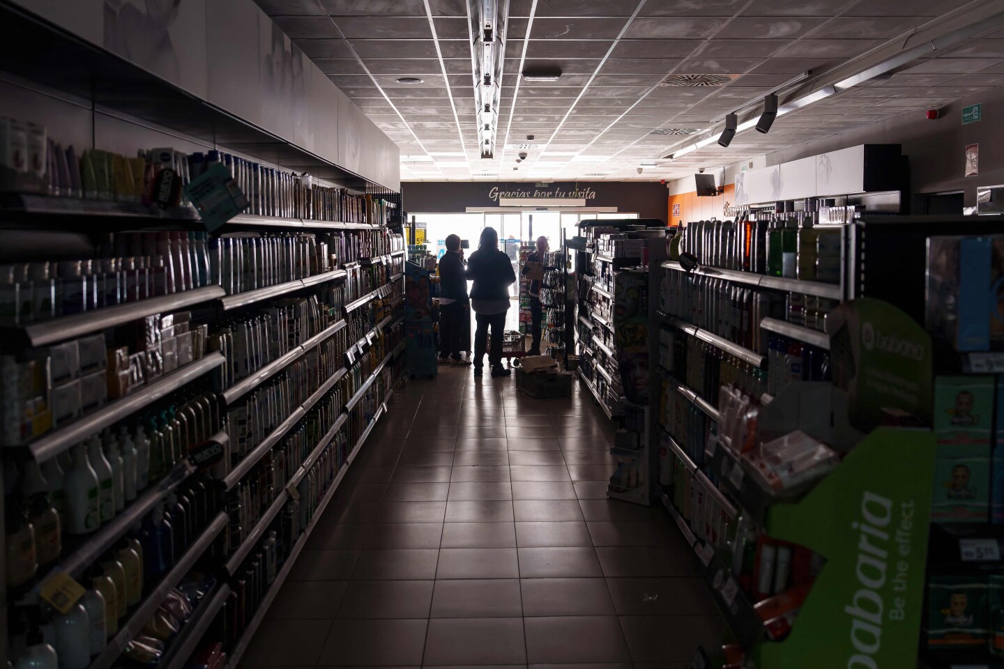 Los empleados permanecen dentro de un supermercado sin luces en Burgos el 28 de abril de 2025, durante un corte de energía masivo.