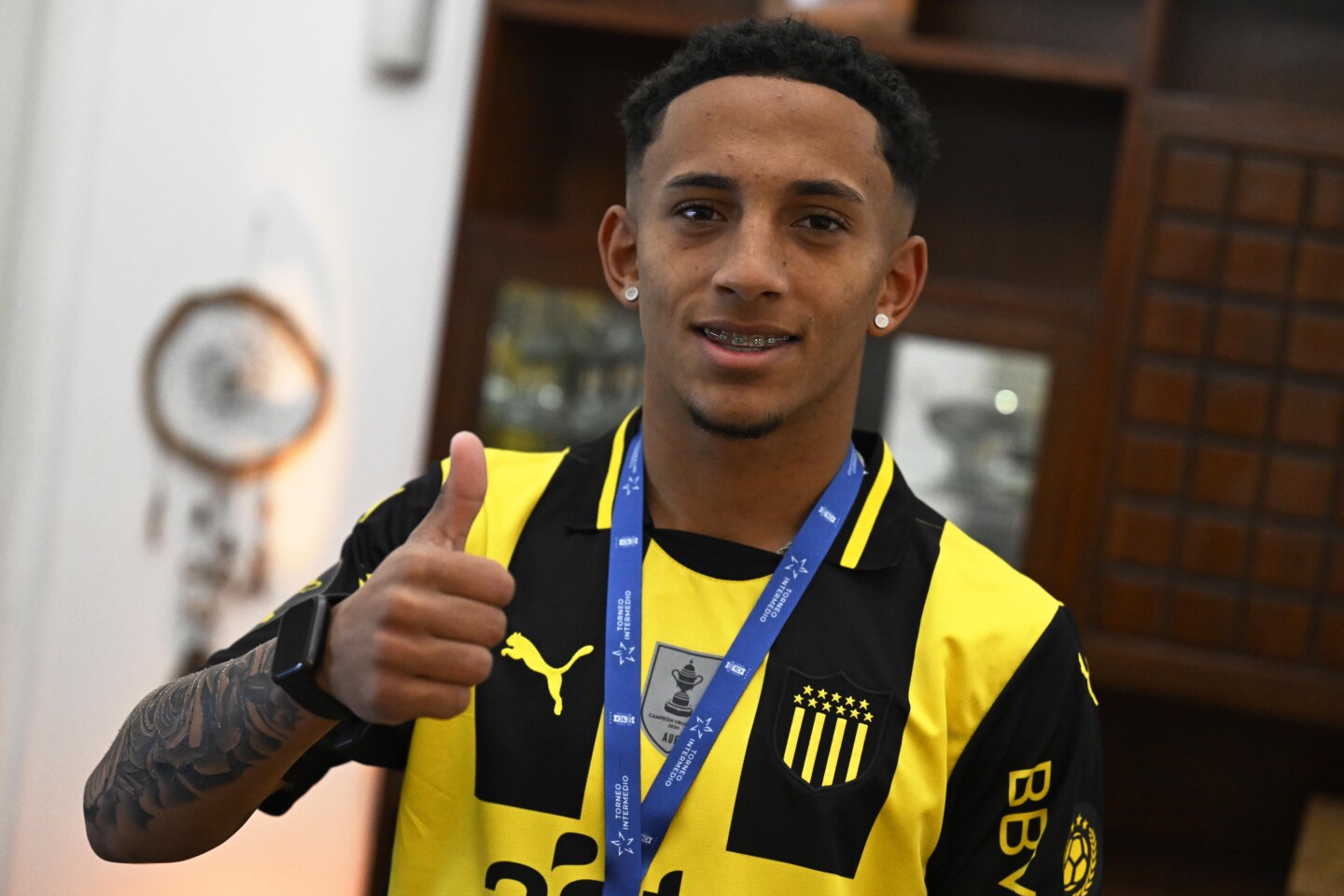 Stiven sonríe ante la cámara de Ovación portando la camiseta de Peñarol y la medalla de campeón del Intermedio.
