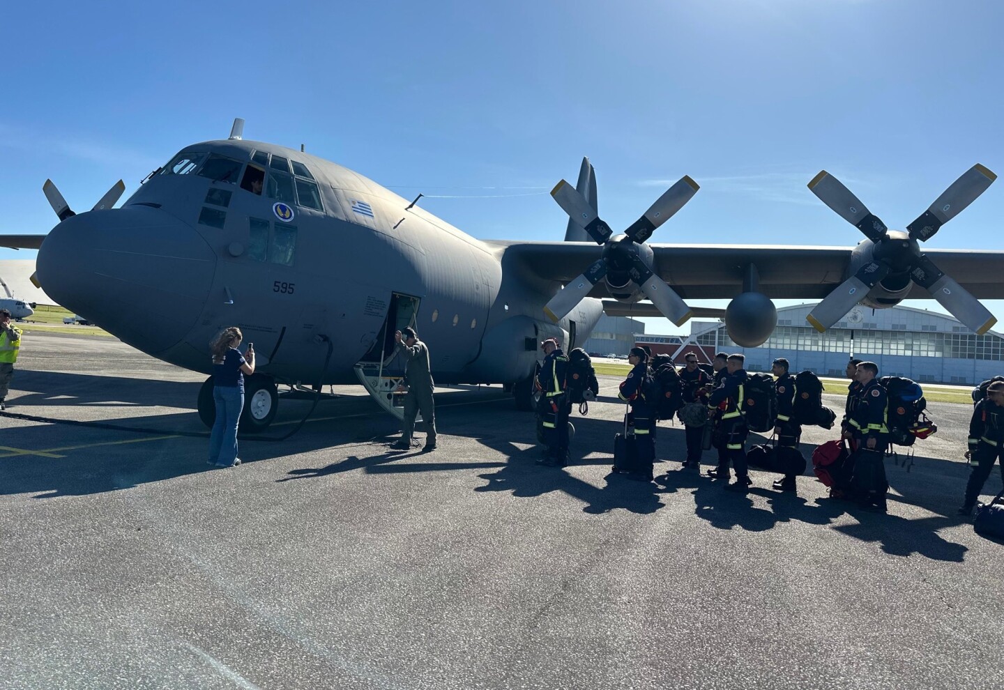 Bomberos subiendo al avión rumbo a Chile para combatir incendios forestales