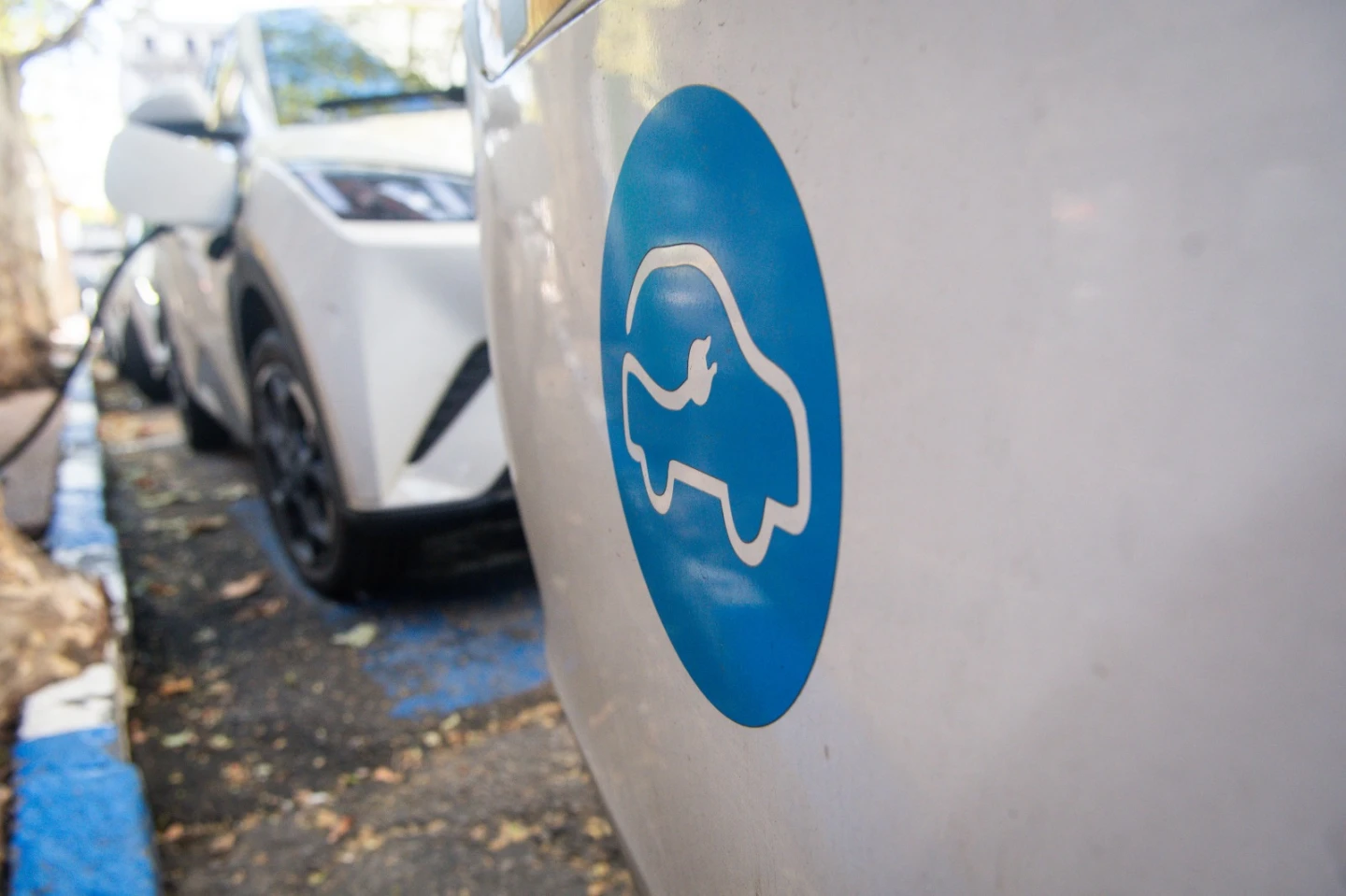 Auto eléctrico en fila junto a otro mientras se están cargando.