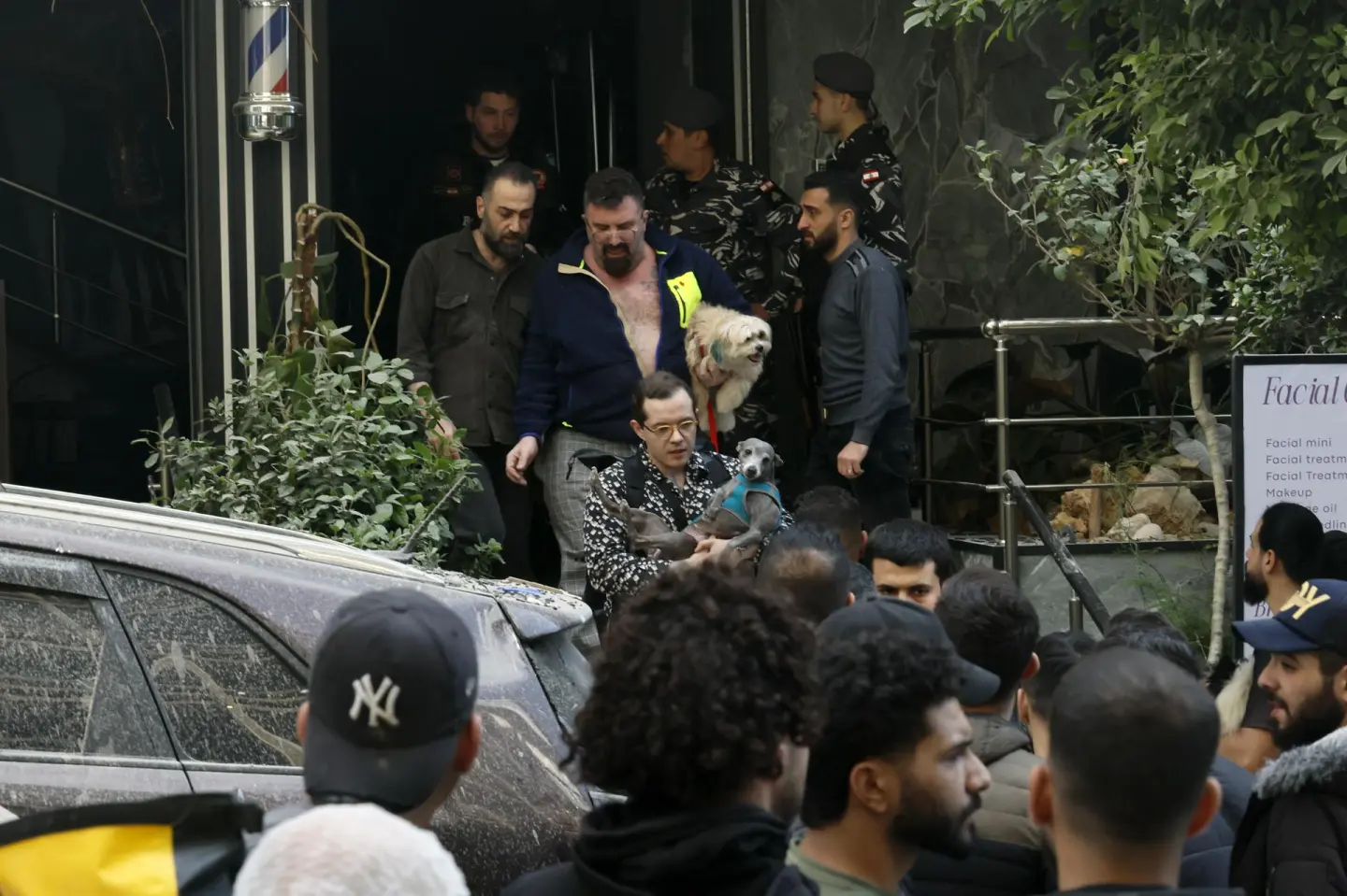 Personas con sus mascotas cerca de un edificio dañado en Beirut.