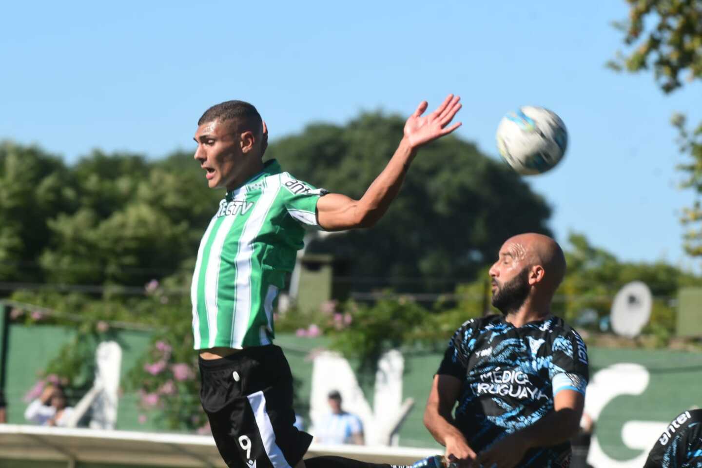 Dylan Nandín salta con Pablo Lacoste  en busca de la pelota.