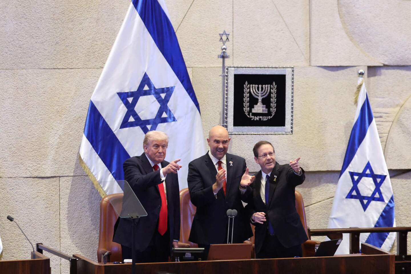 La reacción de Donald Trump al recibir una ovación en la Knéset, el Parlamento israelí. A su lado están Amir Ohana (centro), presidente de la Knéset israelí, y el presidente israelí Isaac Herzog.