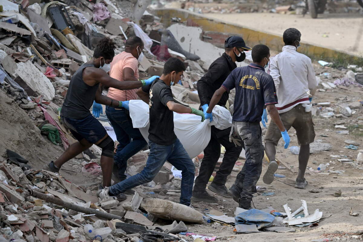 La Guaira. Equipo de rescate transporta cuerpo de una víctima recuperado de entre edificios derrumbados.