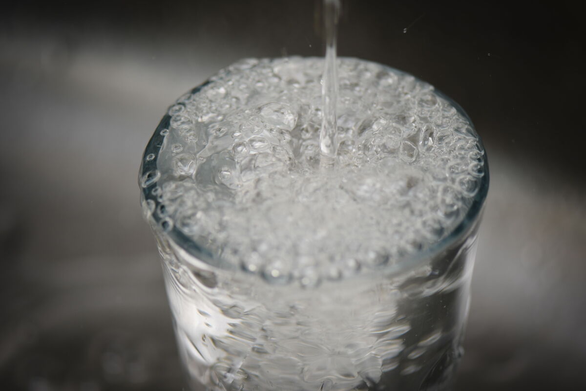 Llenando vaso con agua de la canilla.