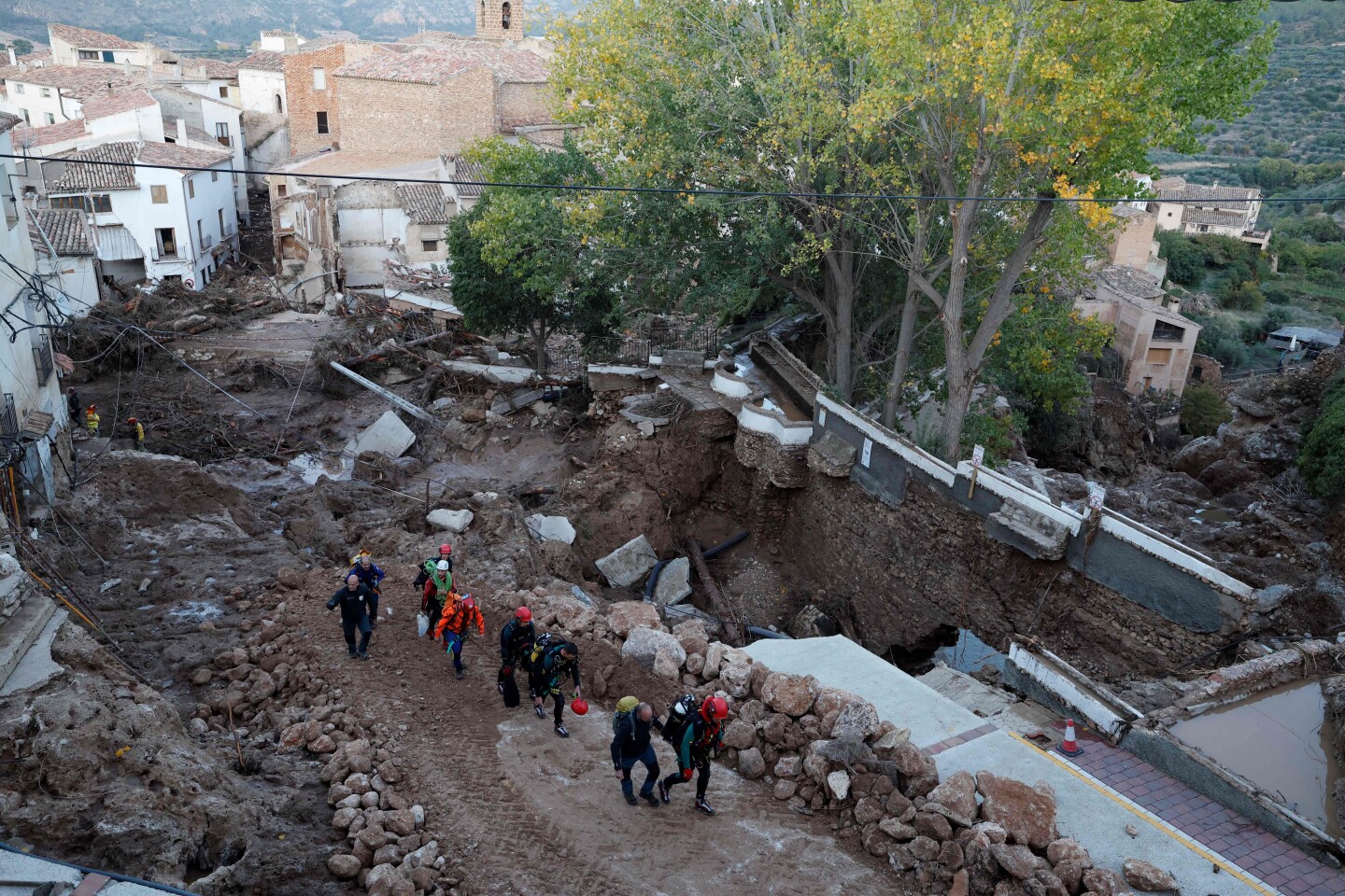 Miembros del personal de los servicios de emergencia caminan por una calle devastada tras las inundaciones en Letur, al suroeste de Valencia.