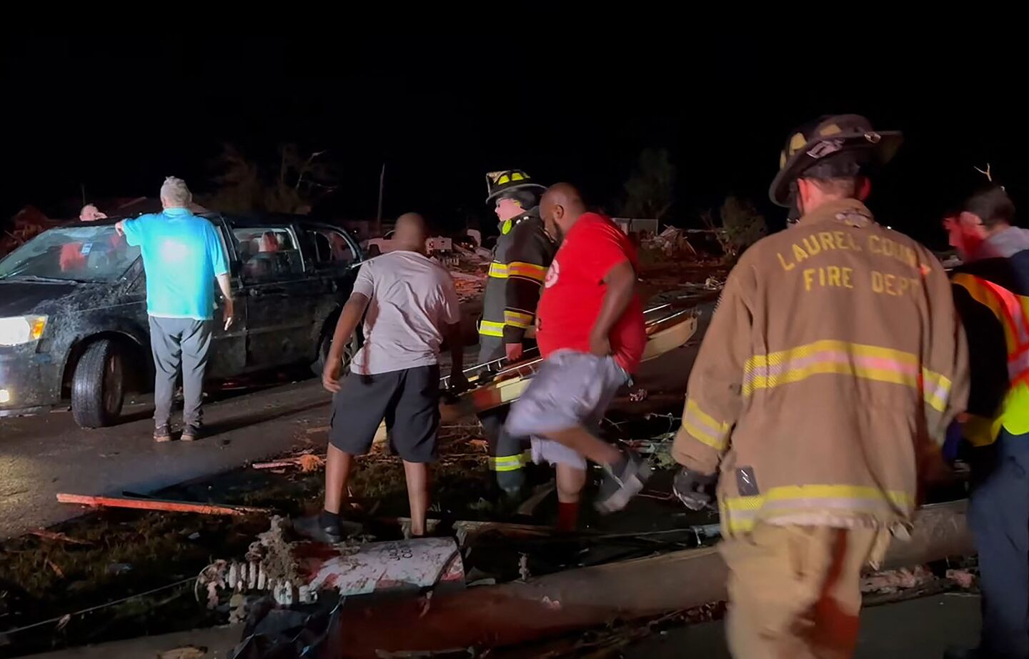 Vecinos buscan entre los daños causados por el tornado en el condado de Laurel, cerca de London, Kentucky