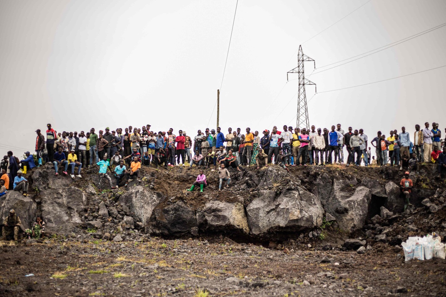 Un grupo de residentes observa los combates a lo lejos desde lo alto de una formación rocosa en la ciudad de Mugunga, a 10 km al noroeste de Goma.