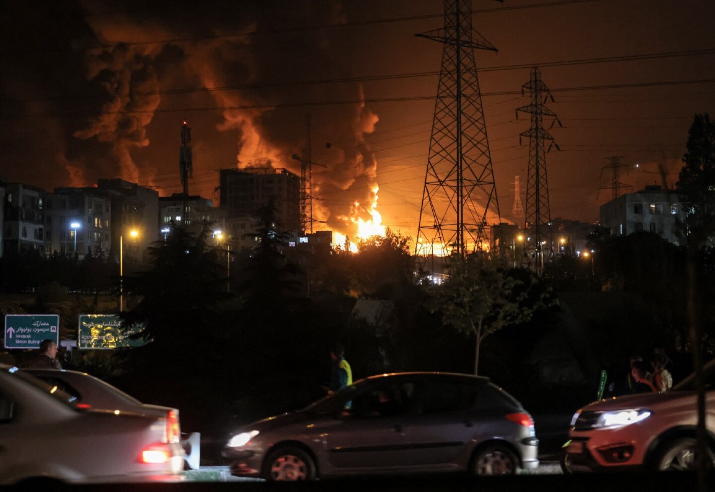 Vehículos atascan una carretera mientras un incendio arde cerca de los depósitos de petróleo de Shahran, al noroeste de Teherán, el 15 de junio de 2025.