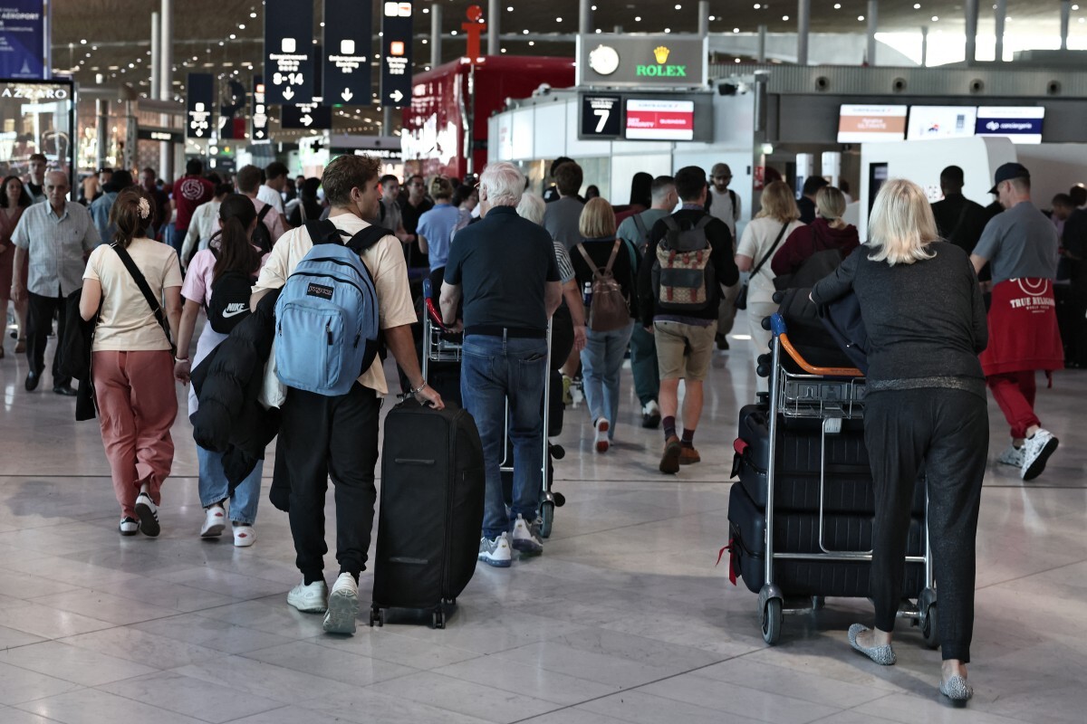 Pasajeros transportan su equipaje en el aeropuerto Roissy Charles-de-Gaulle, a las afueras de París, el 3 de julio de 2025