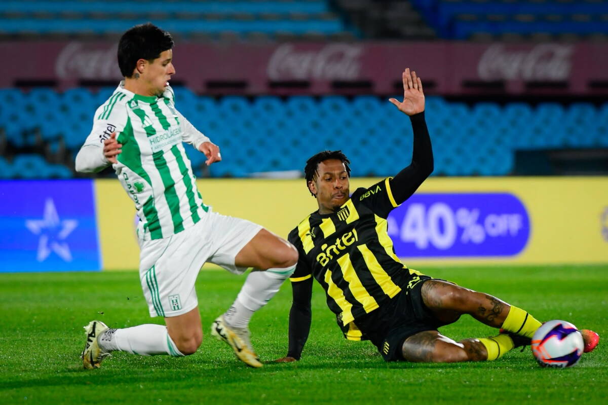 Felipe Álvarez y Abel Hernández disputan la pelota en el partido entre Racing y Peñarol.
