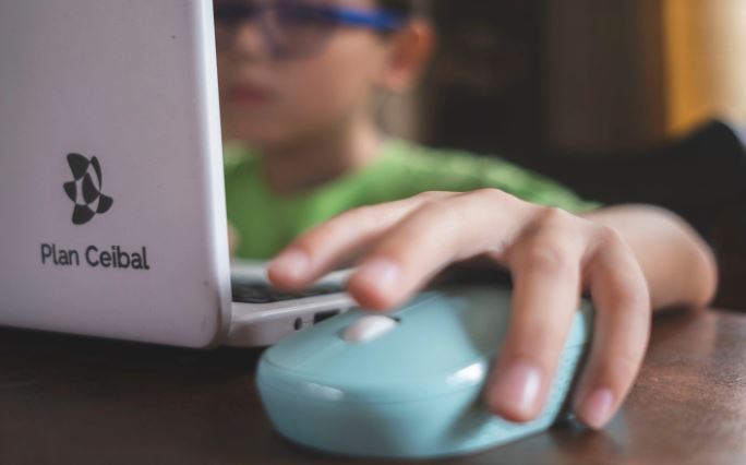 Niño con una computadora del plan Ceibal.