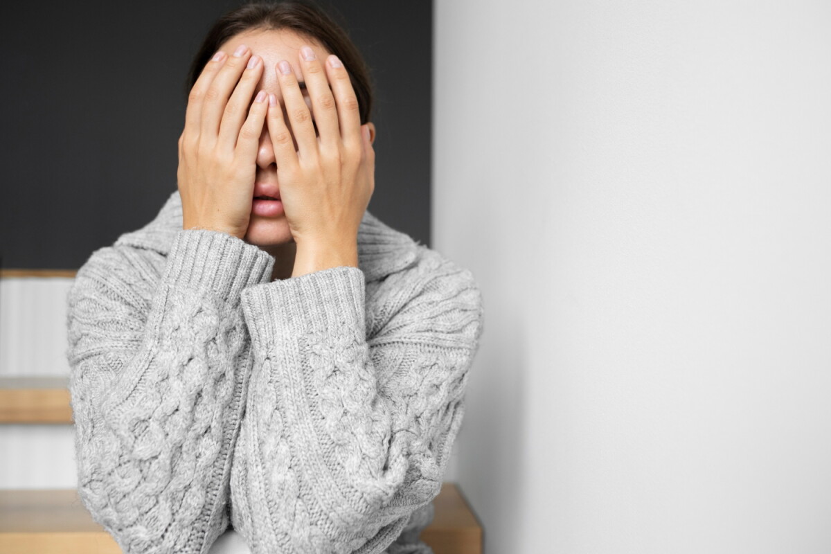 Mujer angustiada cubre su rostro.