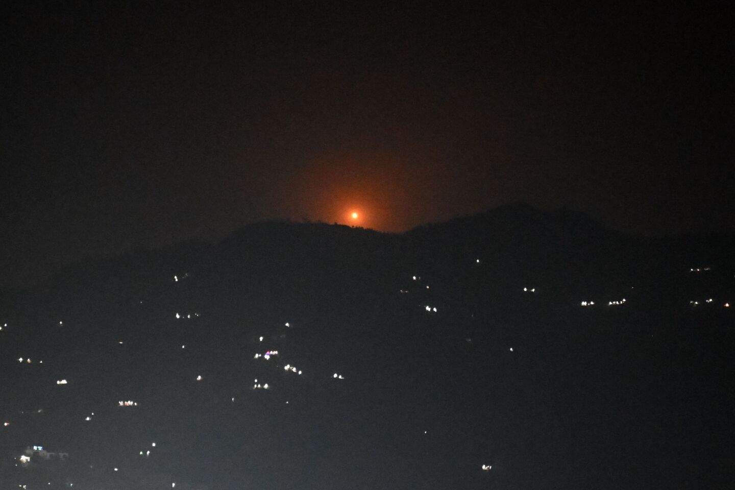 Una bengala se eleva sobre un monte cercano a la ciudad principal del distrito de Poonch, el 7 de mayo de 2025.