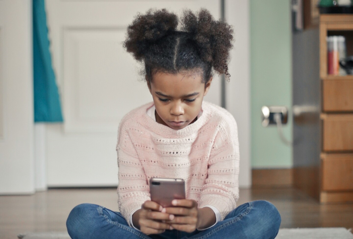 Una niña usando un celular.