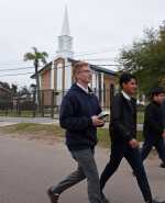 Cuatro misioneros mormones caminan frente a una capilla de la Iglesia de Jesucristo de los Santos de los Últimos Días