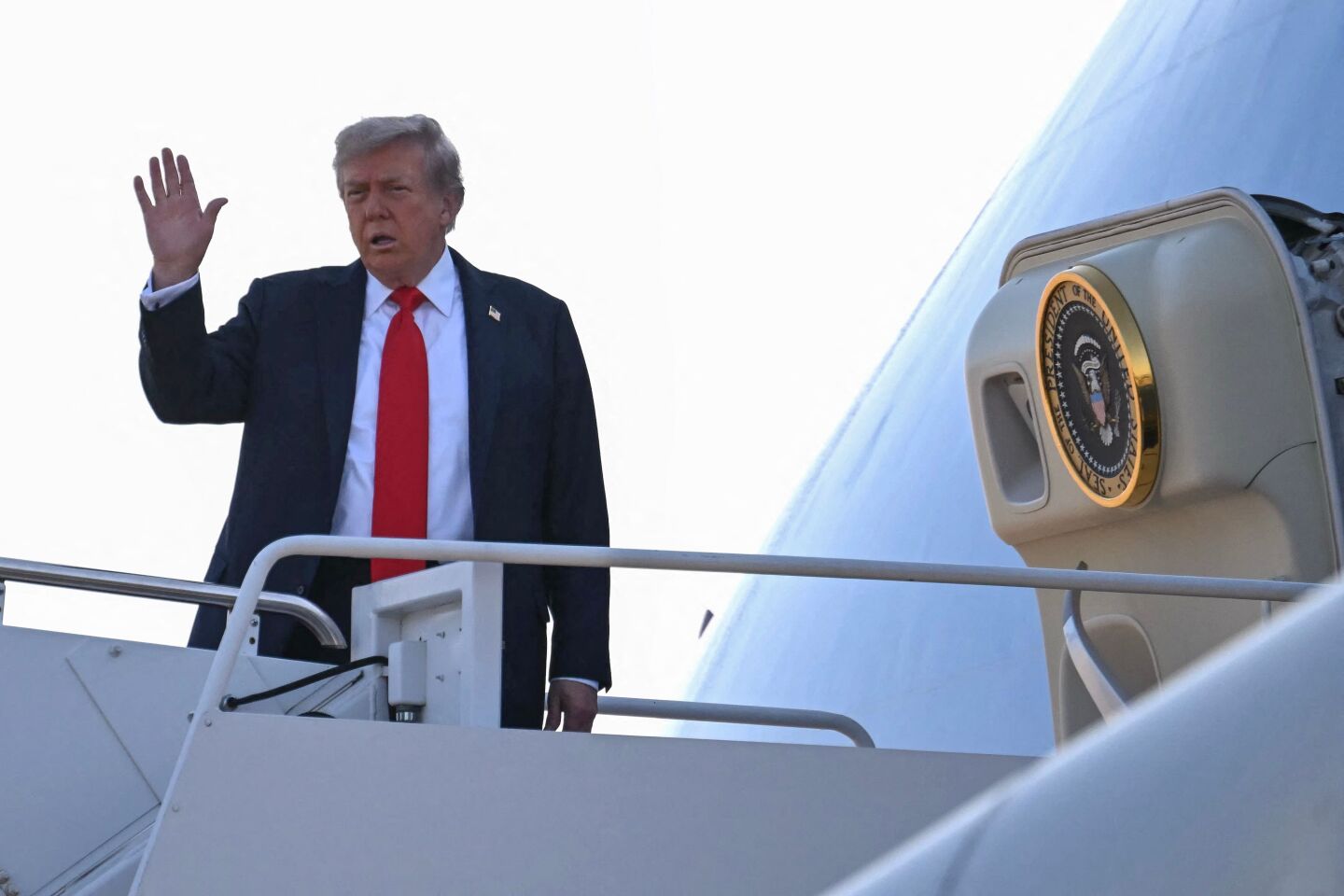 El presidente Donald Trump saluda al abordar el Air Force One al despegar de la Base Conjunta Andrews en Maryland el 15 de agosto de 2025, rumbo a Anchorage