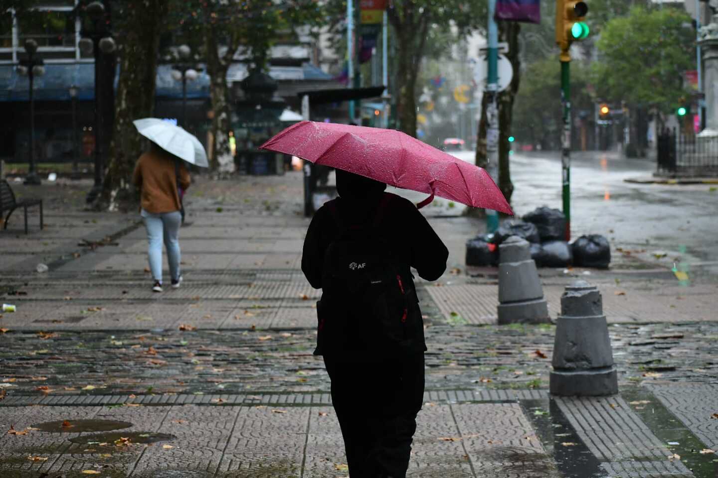 Personas caminan con paraguas por la Plaza Cagancha un día de lluvia.