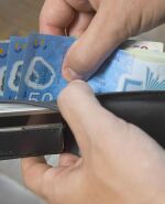 Hombre contando billetes de 50 pesos uruguayos en su billetera. Foto: Darwin Borrelli