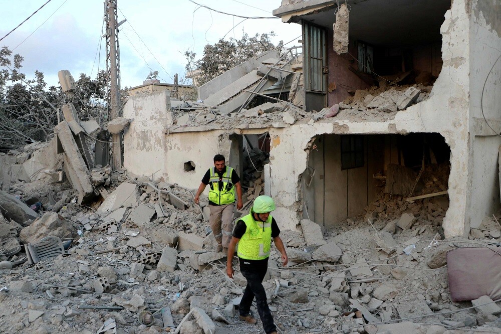 Los rescatistas inspeccionan los daños en el lugar de un ataque aéreo israelí que tuvo como objetivo la aldea de Hanouiyeh, en el sur del Líbano.