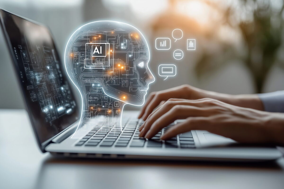 Person uses laptop interacting with AI virtual assistant. AI head graphic overlay laptop keyboard. Concept of AI prompt engineering LLM. Person types on keyboard to communicate with virtual