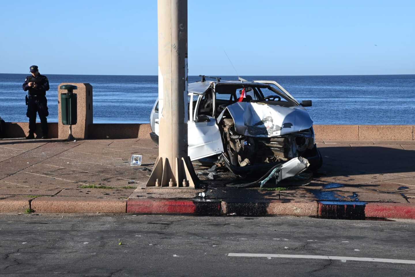 Auto que quedó sobre la vereda de la rambla de Montevideo, tras un siniestro.