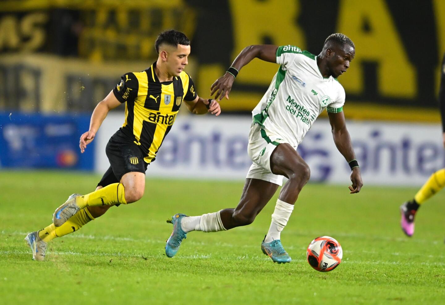 Christian Ebere traslada la pelota ante la marca de Leo Fernández en el Peñarol vs. Plaza Colonia.