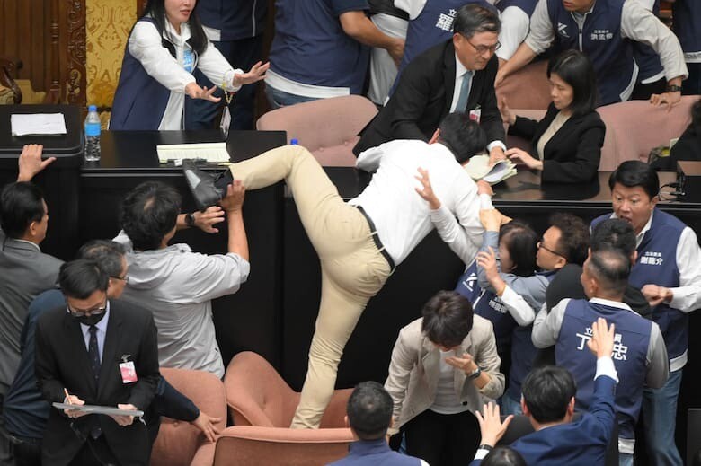 Legislador taiwanés trepando un escritorio.