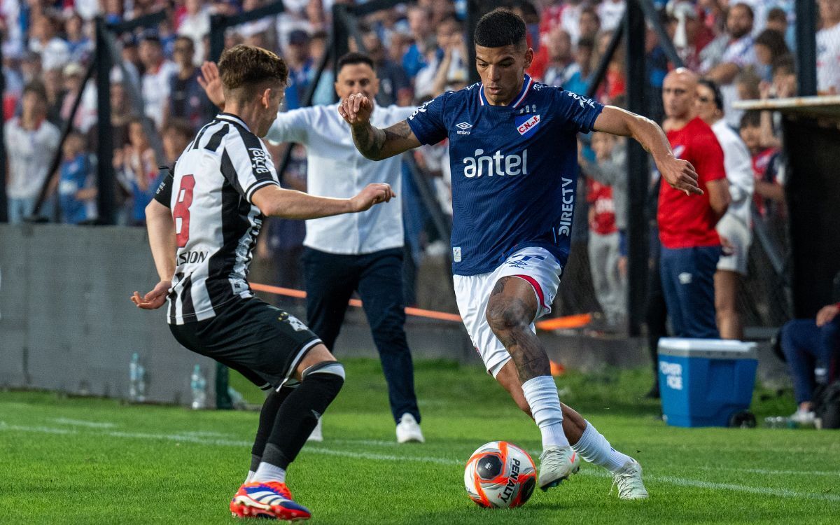 Diego Romero con pelota dominado ante Bruno Veglio en el partido entre Wanderers y Nacional.