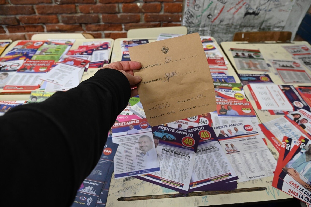Una persona sostiene un sobre de votación en las elecciones departament