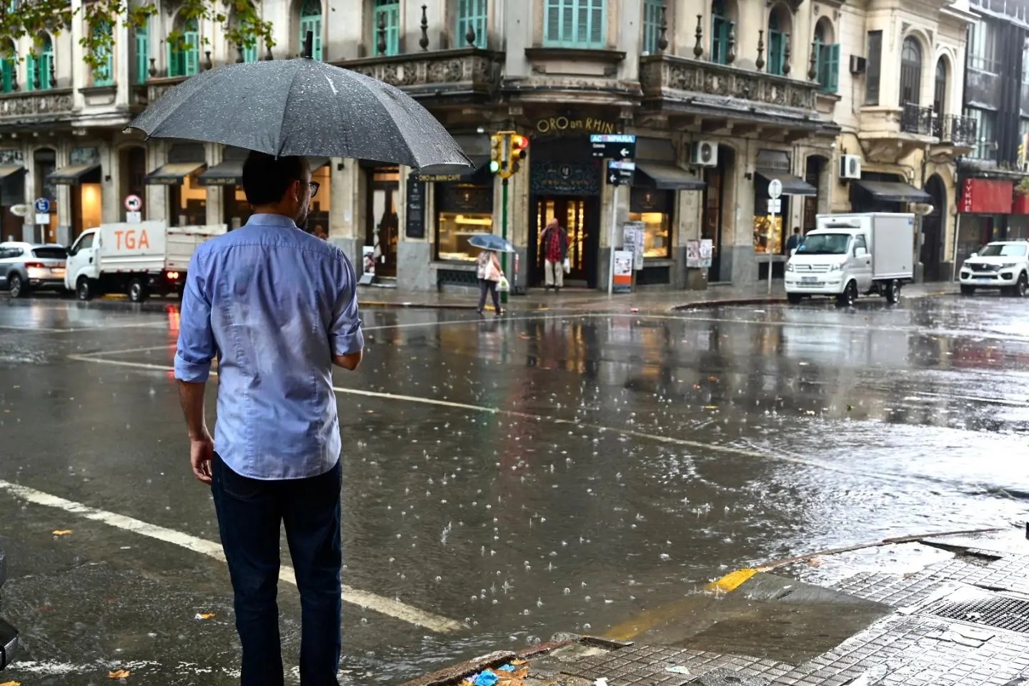Un hombre cruza la calle con paraguas un día de lluvia en Montevideo.