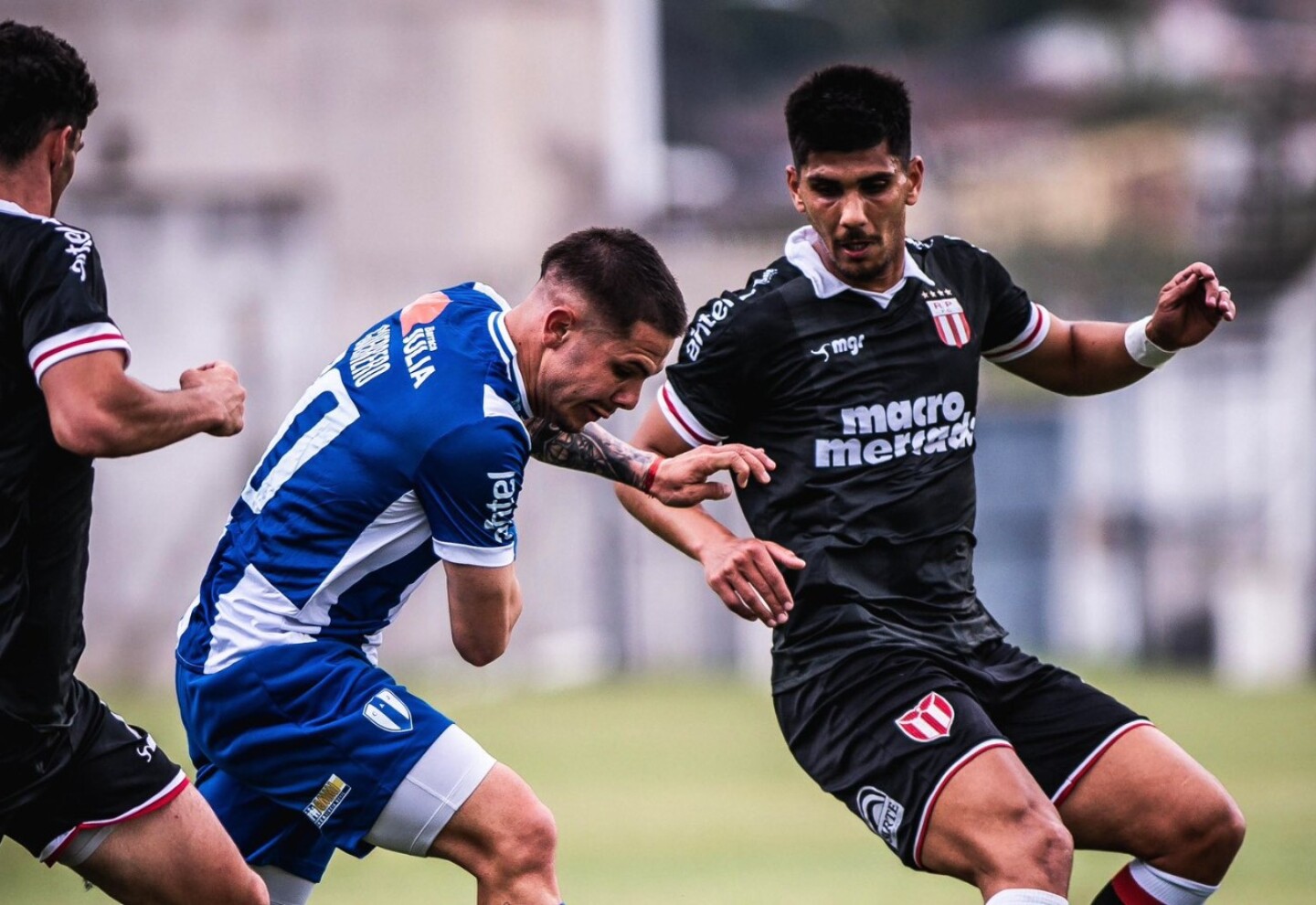 Sebastián Guerrero de Juventud lucha por la pelota ante Emiliano Jourdan y Rodrigo Pollero de River Plate.