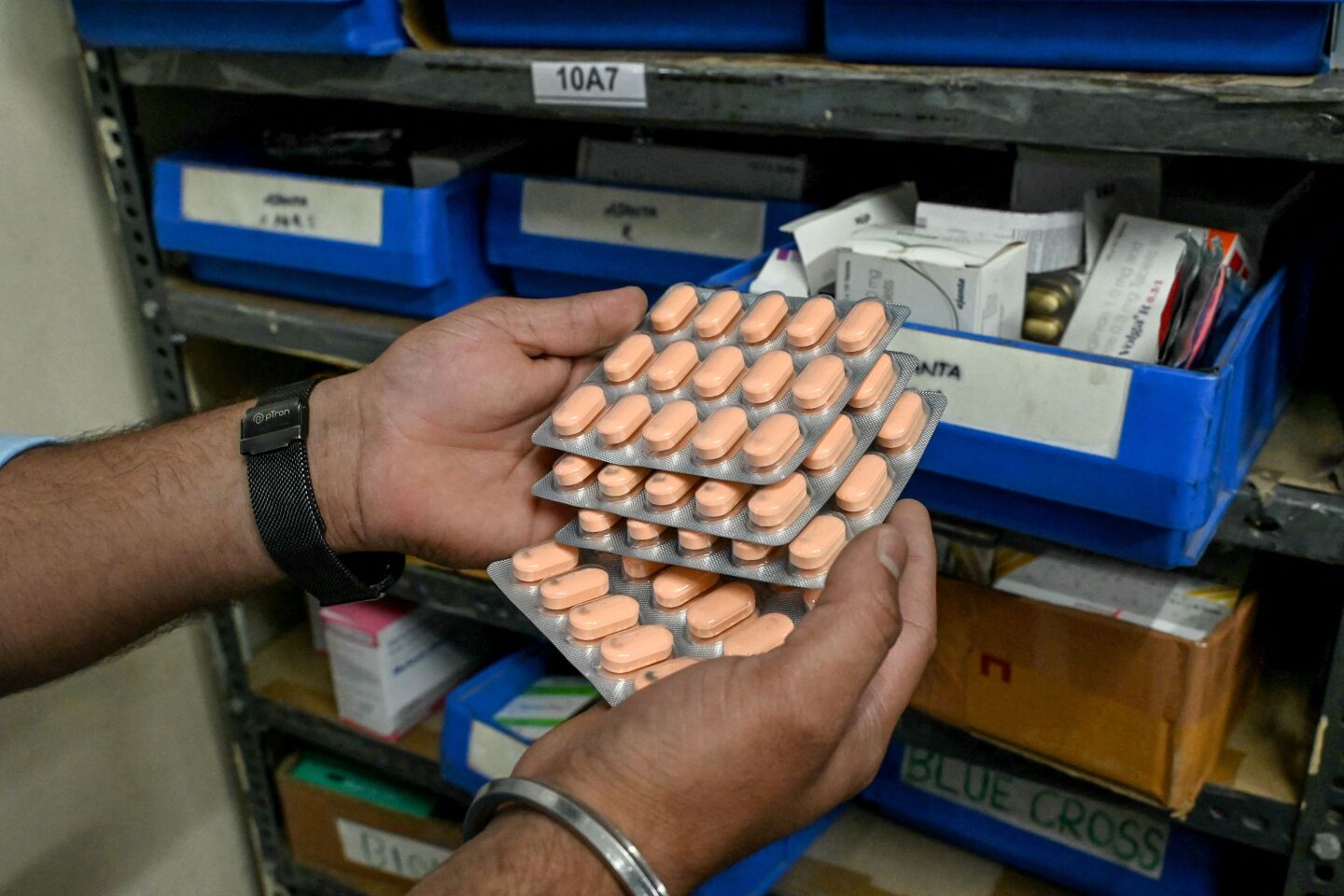 Un farmacéutico comprueba el stock de medicamentos en una farmacia.