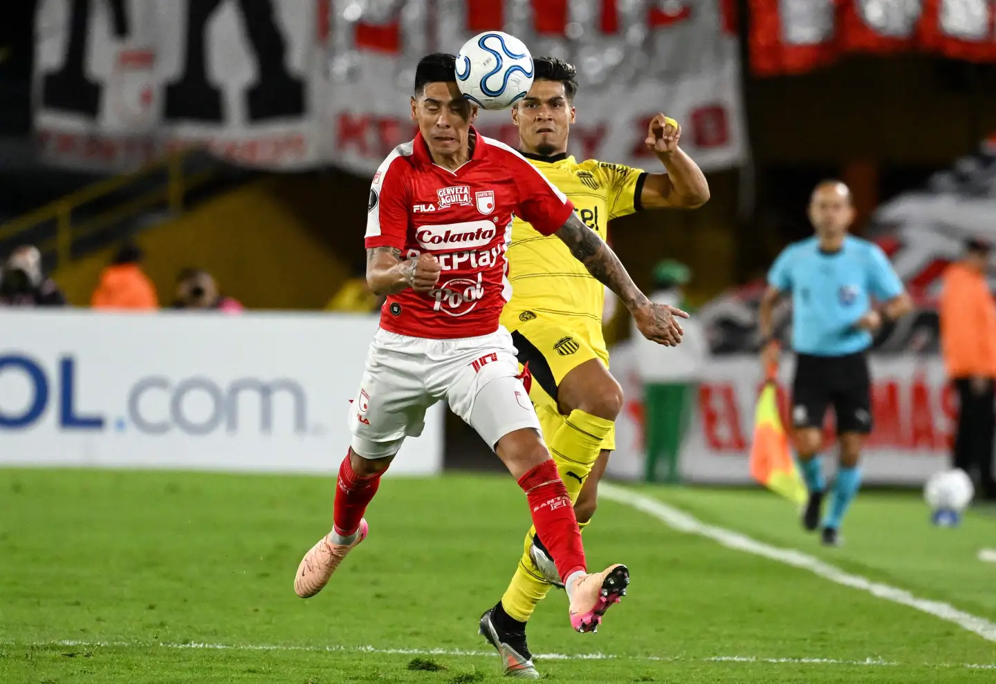 Matías Arezo disputa la pelota con el zaguero Emanuel Olivera en el partido entre Peñarol e Independiente Santa Fe por Copa Libertadores.