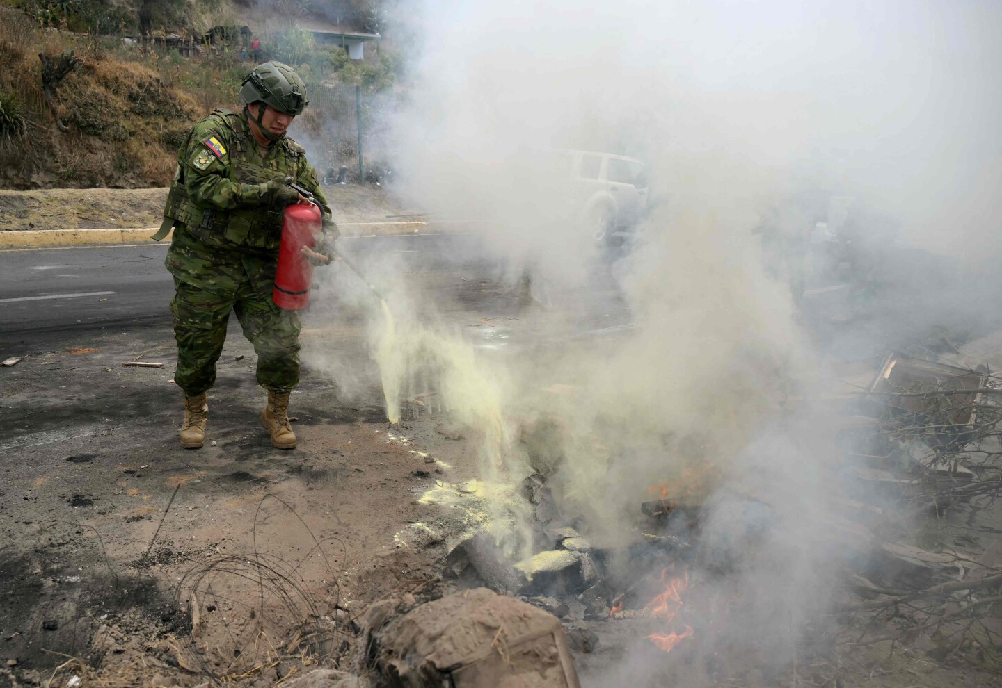 Un militar extingue un incendio en la carretera Panamericana Norte, donde residentes bloquearon la vía durante una protesta contra el fin de los subsidios al diésel en la comuna de San Miguel del Común, cerca de Quito, el 16 de septiembre de 2025.