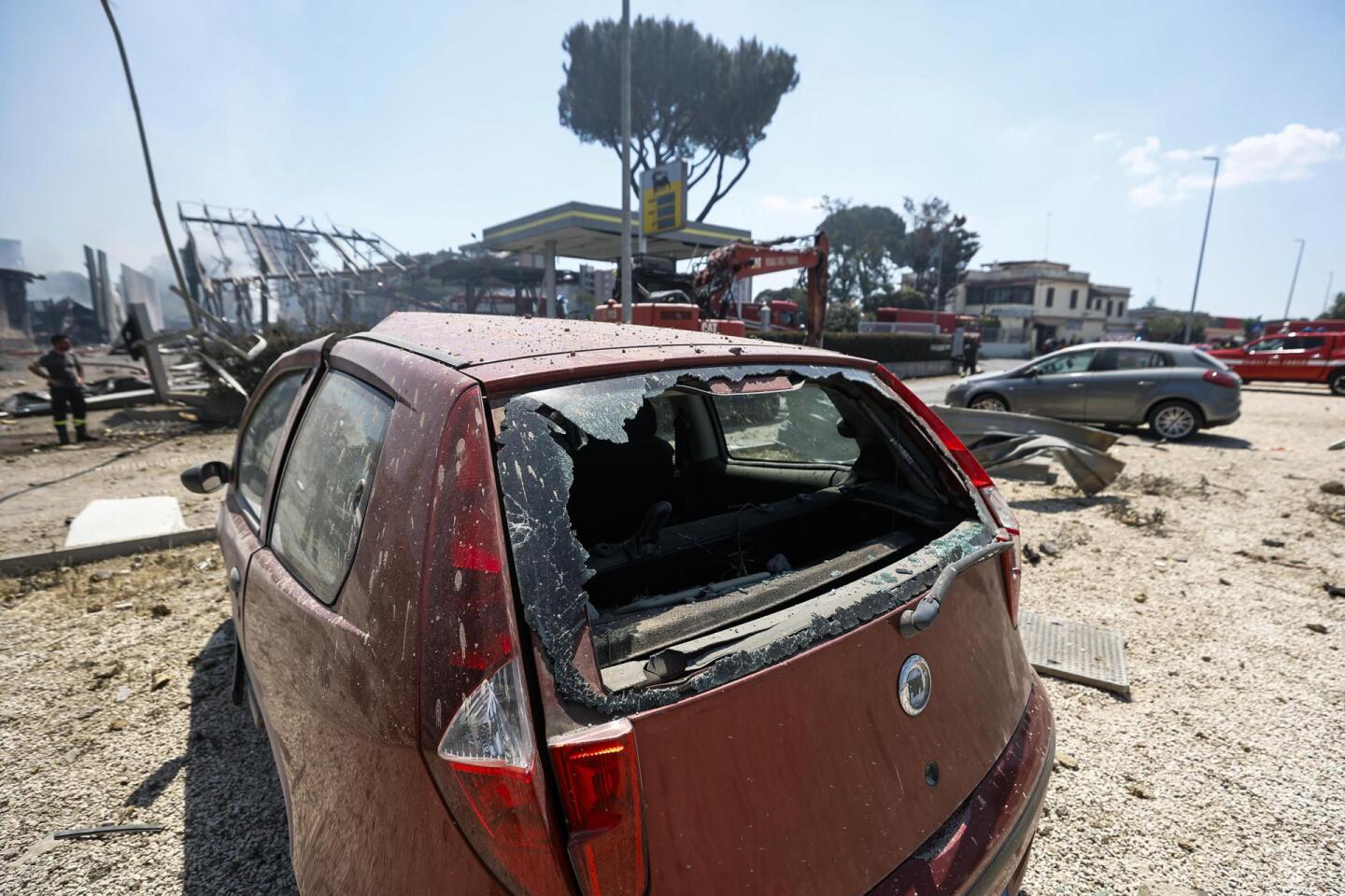 Auto con sus vidrios rotos producto de una explosión en una estación de servicio en Roma.
