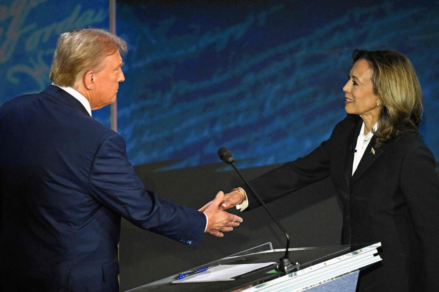 Donald Trump y Kamala Harris se dan la mano en su primer encuentro en persona.