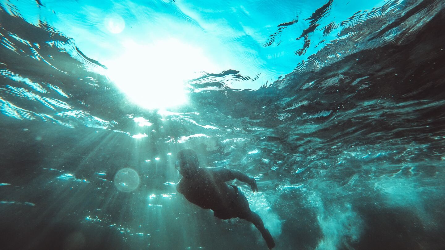 Persona nadando en agua cristalina