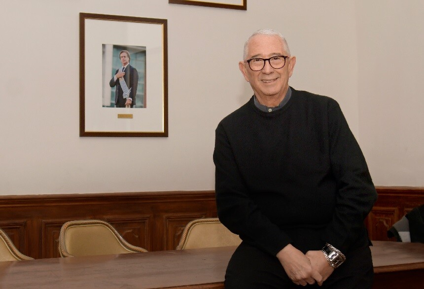Sergio Puglia junto al retrato de Lacalle Pou en la casa del Partido Nacional.