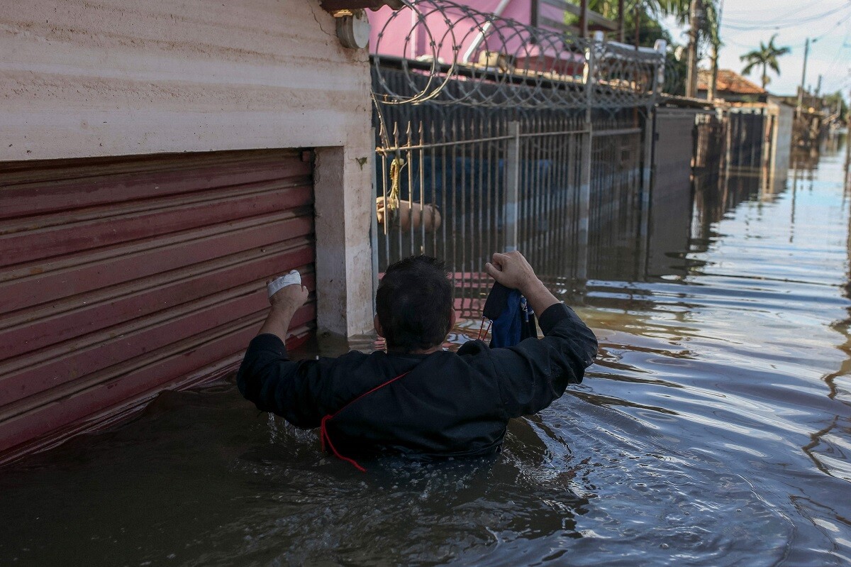 Un hombre regresa a su casa inundada para recuperar ropa de invierno en el barrio de Rio Branco, en Canoas