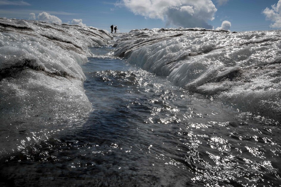Turistas caminan junto a un arroyo de agua de deshielo que fluye desde el glaciar Tsanfleuron sobre Les Diablerets, Suiza. Foto: AFP