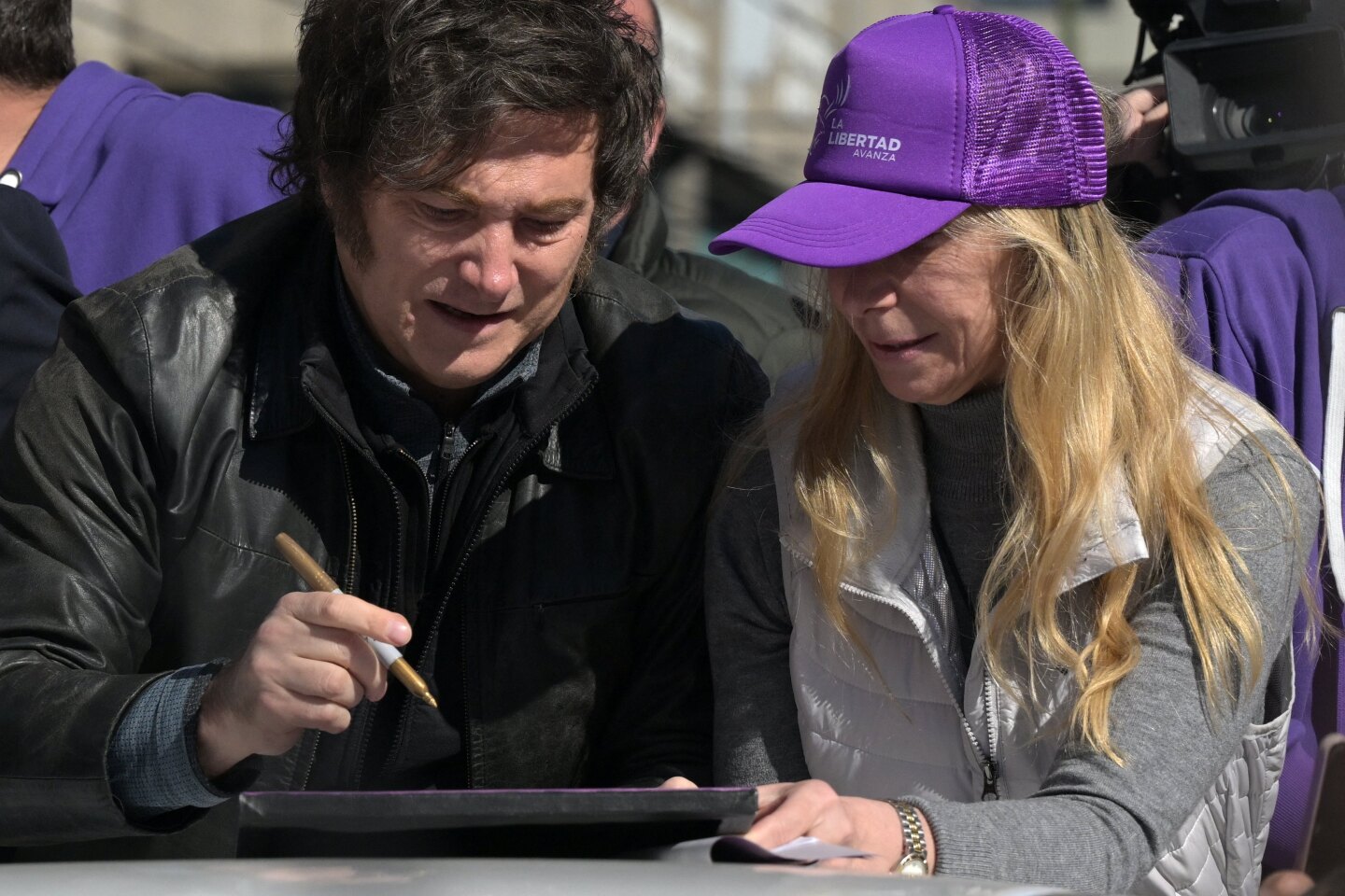 El presidente de Argentina, Javier Milei, firma una fotografía junto a su hermana, la Secretaria General de la Presidencia, Karina Milei.