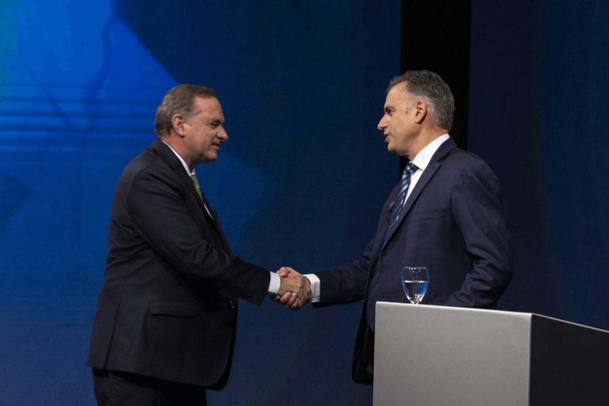 Yamandú Orsi y Álvaro Delgado se saludan durante el debate presidencial.