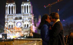 Una pareja se besa frente a la catedral de Notre-Dame de París, en vísperas de su reapertura oficial después de más de cinco años