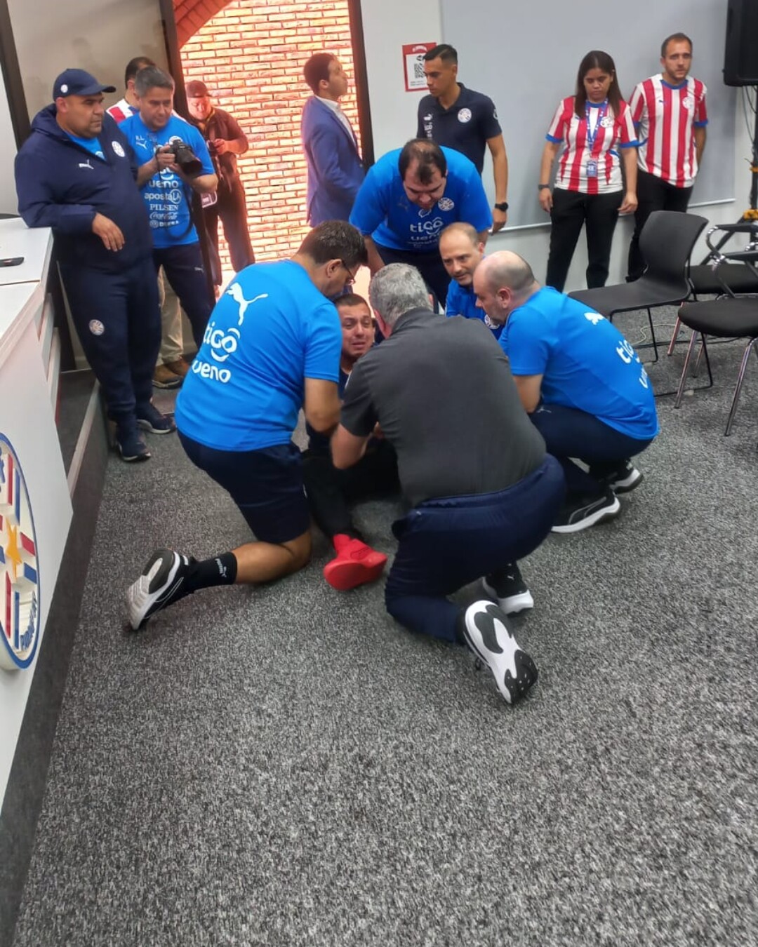 Gustavo Alfaro asiste a un fotógrafo que se desmayó durante la conferencia de prensa.