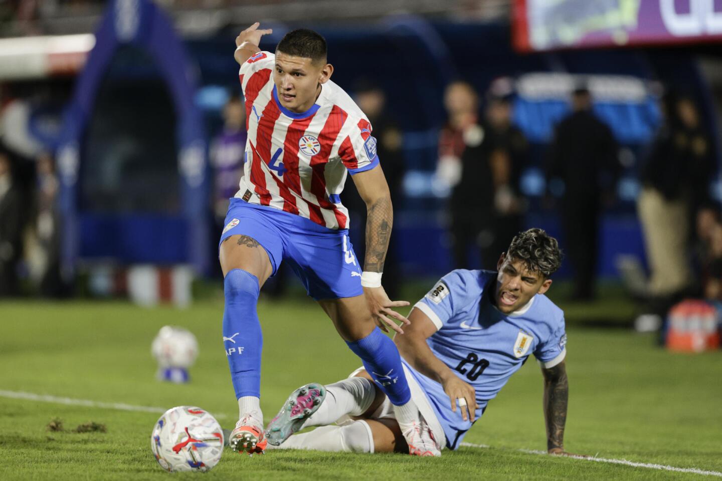 Juan Cáceres ante la marca de Maximiliano Araújo en el partido entre Paraguay y Uruguay por las Eliminatorias rumbo al Mundial 2026.