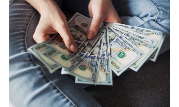 Persona con dólares. Foto: Canva.