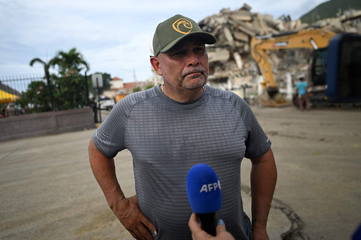 El exjugador venezolano de las Grandes Ligas de Béisbol, Eliezer Alfonzo, frente a los escombros del Hotel Eduard's.