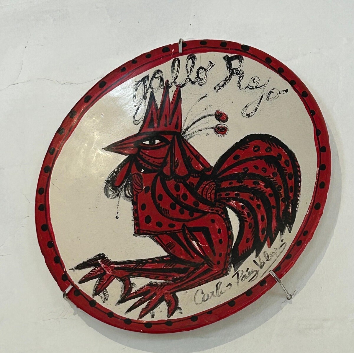 El plato original que pintó Carlos Páez Vilaró con el nombre y logo de "El Gallo Rojo", la parrillada que tuvo en la casa de Las Grutas.